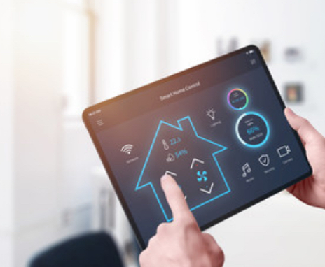 Hand tippt auf Tablet, auf dem die Energieeffizienz eines Hauses angezeigt wird.
