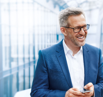 Mann mit Smartphone in gläserner Halle.